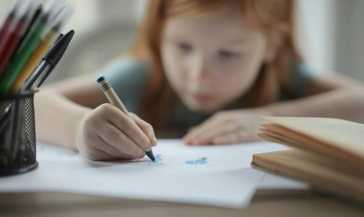 A girl drawing pictures on a piece of paper