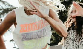 A blonde woman in brightly coloured clothes doing Zumba